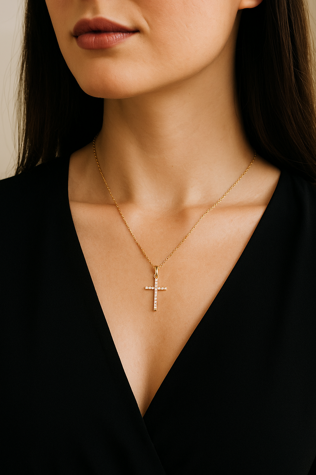Close-up of a person wearing a gold necklace with a cross pendant.